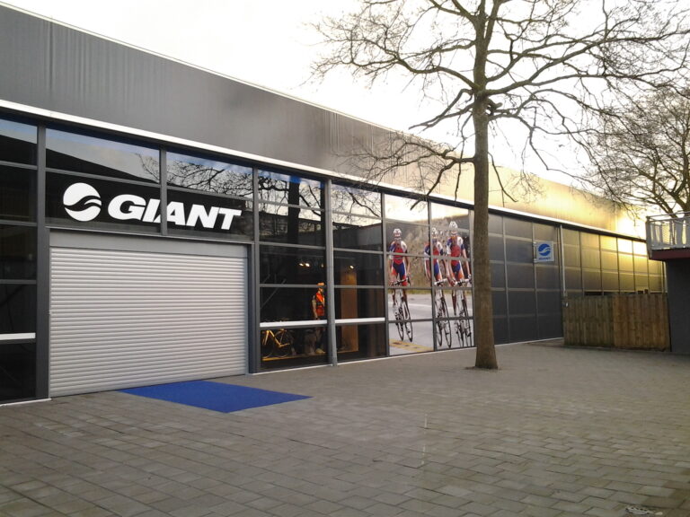 Gevel van het Experience Center van Giant Bicycles met roldeur en showroomramen